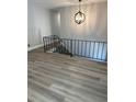 Bright hallway featuring wood floors, an iron railing, and a modern chandelier at 2764 Ocean Valley Dr, Atlanta, GA 30349