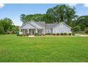 Lovely one-story home with expansive green lawn, tidy landscaping, and inviting covered entryway at 905 S Cherokee Rd, Social Circle, GA 30025