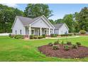 Quaint single-story house with neat landscaping, vibrant green grass, and classic architectural details at 905 S Cherokee Rd, Social Circle, GA 30025