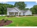 Attractive single-story home featuring lush green lawn, mature landscaping, and inviting front porch at 905 S Cherokee Rd, Social Circle, GA 30025
