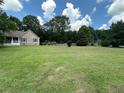Spacious lawn with lush green grass and mature trees, partially enclosed by a white picket fence at 10 Vaughan Ne Ct, Cartersville, GA 30121