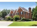 Side view of brick home showcasing the architectural details and large chimney at 6310 Buckingham Pl, Cumming, GA 30040