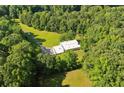 Expansive aerial view showcases a modern home nestled within a dense, green forest at 110 Bridger Point Rd, Fayetteville, GA 30215