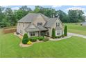 Beautiful two-story home with a well-kept lawn, lush landscaping, and a long driveway at 108 Donovan Ave, Locust Grove, GA 30248