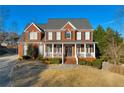 Beautiful two-story brick home featuring a classic design and covered front porch at 4055 Inman Park Ln, Buford, GA 30519