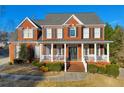 Attractive brick home with a welcoming covered porch and lush greenery at 4055 Inman Park Ln, Buford, GA 30519