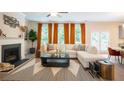 Inviting living room with cozy fireplace, plush sofa, and natural light from large windows at 525 Paces Dr, Lithia Springs, GA 30122