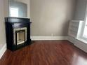 Cozy living room with a decorative fireplace, built-in shelving, and hardwood floors at 3155 E East Point E St, East Point, GA 30344