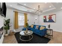 Stylish living room features a blue sectional, fireplace, modern decor, and bright window with vibrant curtains at 749 Bonnie Brae Sw Ave, Atlanta, GA 30310