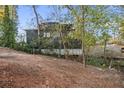 Rear view of a home showcasing the backyard and its relationship to the surrounding wooded landscape at 5861 Community Rd, Mableton, GA 30126