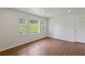 Inviting living room with hardwood floors, white trim and three large windows at 5861 Community Rd, Mableton, GA 30126