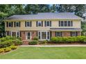Inviting two-story home boasts a brick facade and beautifully landscaped front yard at 1416 Vernon Ridge Close, Dunwoody, GA 30338