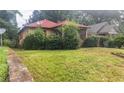 Exterior shot of a single-story home, with a red roof and overgrown landscaping at 969 Byron Sw Dr, Atlanta, GA 30310