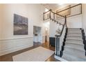 Elegant foyer with soaring ceilings, a staircase with decorative railings, and hardwood floors with a decorative area rug at 10650 Centennial Dr, Alpharetta, GA 30022