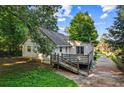 View of back exterior featuring a deck and a driveway with some greenery at 6719 Sunset Valley Cir, Rex, GA 30273