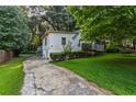 Driveway view of house exterior with a well-maintained lawn and mature trees at 6719 Sunset Valley Cir, Rex, GA 30273