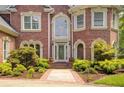 Close up of a charming brick home with manicured landscaping and a decorative entry door at 1350 Whitley Rd, Dacula, GA 30019