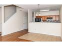 Open kitchen area with wooden cabinets and a breakfast bar, adjacent to a staircase at 2284 Nicole Dr, Hampton, GA 30228