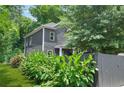 Gray two-story house featuring a well-kept lawn and a dark fenced perimeter at 935 Pelham Nw St, Atlanta, GA 30318