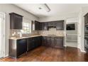 This kitchen boasts stainless steel appliances, granite counters, dark wood cabinets, and hardwood floors at 2251 Fall Creek Lndg, Loganville, GA 30052
