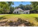 A view of the side yard of a two-story home with black shutters and green lawns at 12550 Hutcheson Ferry Rd, Palmetto, GA 30268