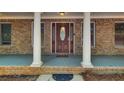 Up close front porch view shows an ornate front door, classic columns, and brick detailing at 155 Skyview Dr, Social Circle, GA 30025