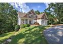 Charming two-story home featuring a lush green lawn, a covered front porch and beautiful architectural details at 16 Cambridge Way, Cartersville, GA 30121