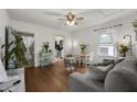 Bright living room featuring hardwood floors, a comfortable gray sofa, and an open view to the kitchen and bathroom at 818 Virgil Ne St, Atlanta, GA 30307