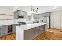 Modern kitchen with gray cabinets, quartz countertops, stainless steel appliances, and hardwood floors at 8671 Lake Forrest Dr, Douglasville, GA 30134