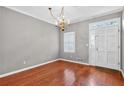 Sunlit dining area featuring hardwood floors, classic chandelier, and entry with large picture window at 2197 Spring Walk Ct, Atlanta, GA 30341