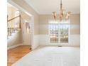 Elegant dining room featuring a chandelier, large windows, and neutral carpeting at 1290 Mount Mckinley Dr, Grayson, GA 30017