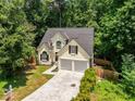 Angle view of a two-story home with a dark roof and attached two-car garage on a wooded lot at 7167 Stonebrook Ln, Lithonia, GA 30058