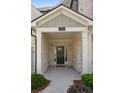 Inviting front porch with stately columns and an elegant entrance, enhanced by lush greenery at 614 Denali Dr, Mableton, GA 30126