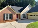 Close up showing the exterior of the home with brick and siding as well as a two car garage at 5415 Windcrest Ln, Suwanee, GA 30024