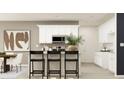 Bright kitchen featuring white cabinets, stainless steel appliances, granite countertops, and breakfast bar seating at 2477 Cotton Ln, Douglasville, GA 30135