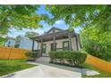 Lovely home showcasing a covered front porch with a ceiling fan, surrounded by mature landscaping and green lawn at 556 Paines Nw Ave, Atlanta, GA 30318