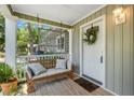 View of front porch with hanging bench, front door with wreath, and plants at 111 Marona Street Ne Ne St, Atlanta, GA 30307