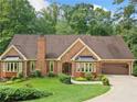 Charming brick home with mature landscaping, a two-car garage, and a welcoming entrance at 3436 Laurelwood Ne Ct, Roswell, GA 30075