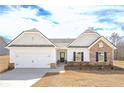 Charming single-Gathering home with stone accents, a two-car garage, and manicured lawn on a sunny day at 494 Charleston Pl, Villa Rica, GA 30180