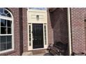 Close-up of the front door featuring brick accents and a decorative light fixture at 4990 Arbor View Nw Pkwy, Acworth, GA 30101
