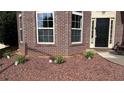 Attractive landscaping with red gravel and new shrubbery accents the front of the brick home at 4990 Arbor View Nw Pkwy, Acworth, GA 30101