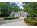 Charming gray home with circular driveway, water feature, and lush landscaping at 9125 Patrick Pl, Winston, GA 30187