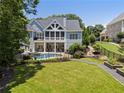 Beautiful backyard featuring a refreshing pool, screened porch, lush lawn, and landscaped garden at 2429 Kirk Nw Ln, Kennesaw, GA 30152