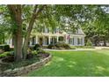 Charming two-story home with a welcoming front porch, lush lawn, and mature landscaping at 2429 Kirk Nw Ln, Kennesaw, GA 30152
