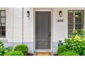 Close-up of charming townhome front door with white brick and a well-manicured front garden at 328 Stonemont Dr, Atlanta, GA 30305