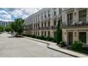Street view of townhomes with white brick, balconies, gray doors, and well-manicured gardens at 328 Stonemont Dr, Atlanta, GA 30305