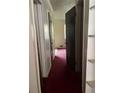Narrow hallway with doors and carpet, leading to another room with a window at 6354 Shannon Pkwy # 12D, Union City, GA 30291