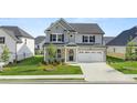 Charming two-story home with grey and white brick exterior, a well-manicured lawn, and a two car garage at 13568 Whitman Lane, Covington, GA 30014