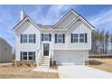 Charming two-story home with white siding, black shutters, and an attached two car garage at 500 Charleston Pl, Villa Rica, GA 30180