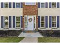 Charming home entrance featuring a white front door with a floral wreath and brick accents at 2505 Hamilton Parc Ln, Buford, GA 30519